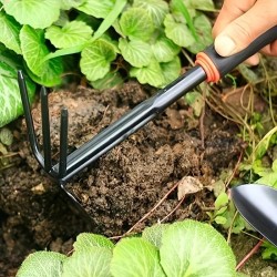 Un ensemble de quatre outils de jardinage extérieur comprenant une petite pelle pour la plantation de fleurs, un râteau à cinq